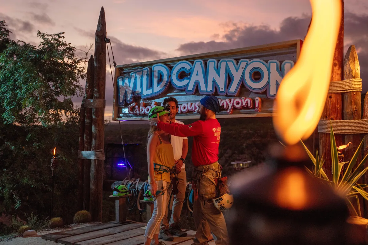 The Wild Canyon sign lit by fire at dusk
