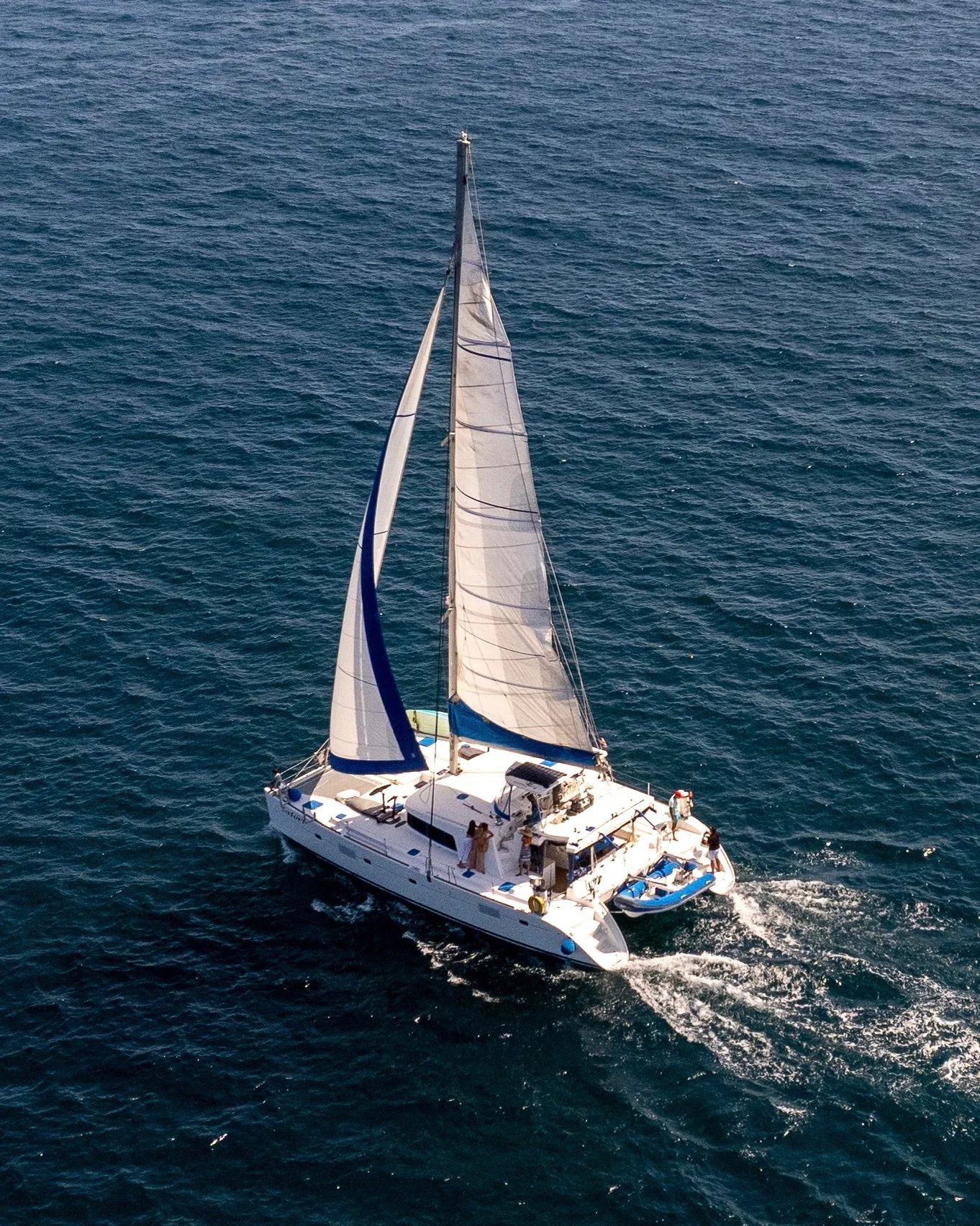 The Satori catamaran under full sail off the coast of Los Cabos