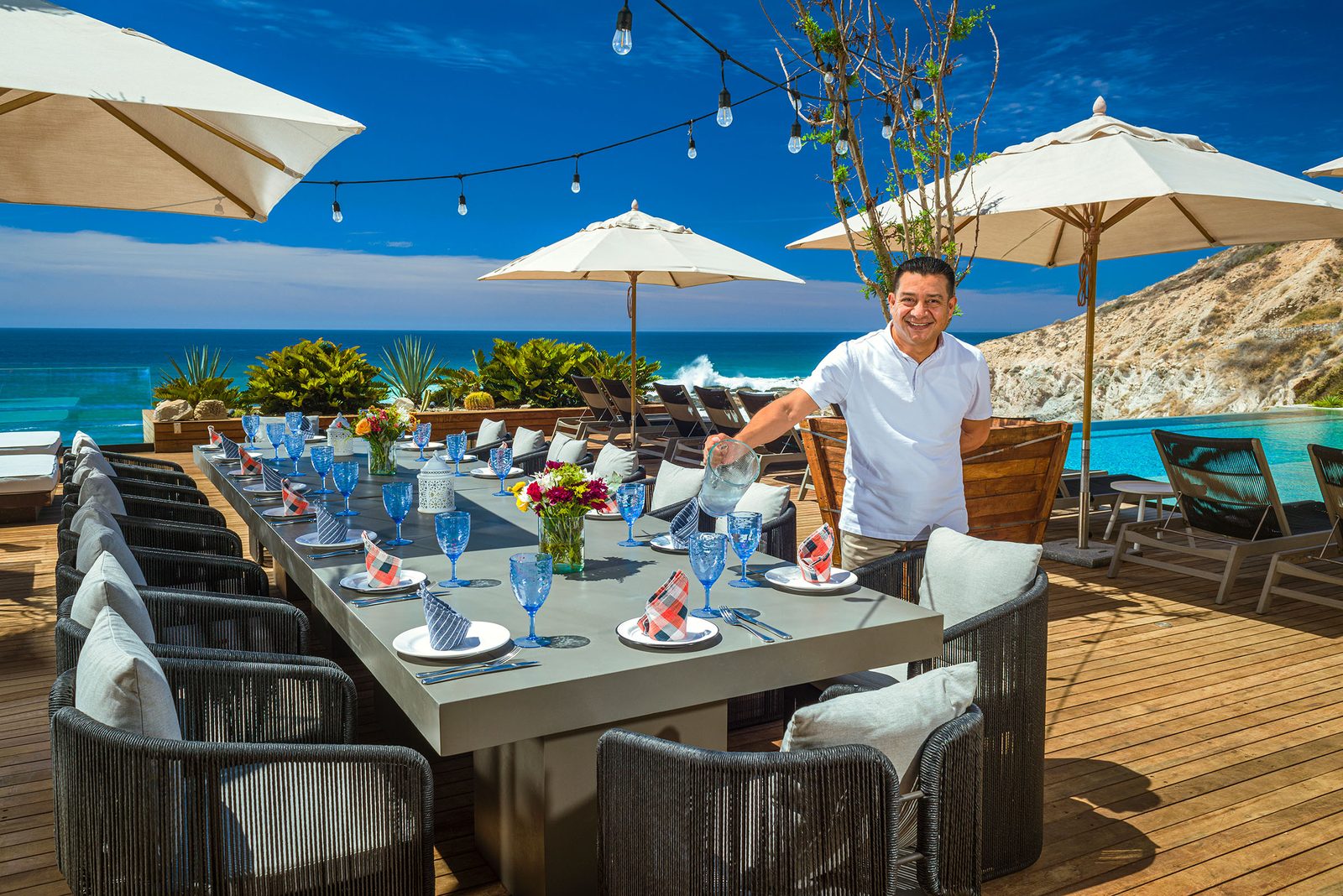 Villa butler setting an oceanview table for dinner in Los Cabos