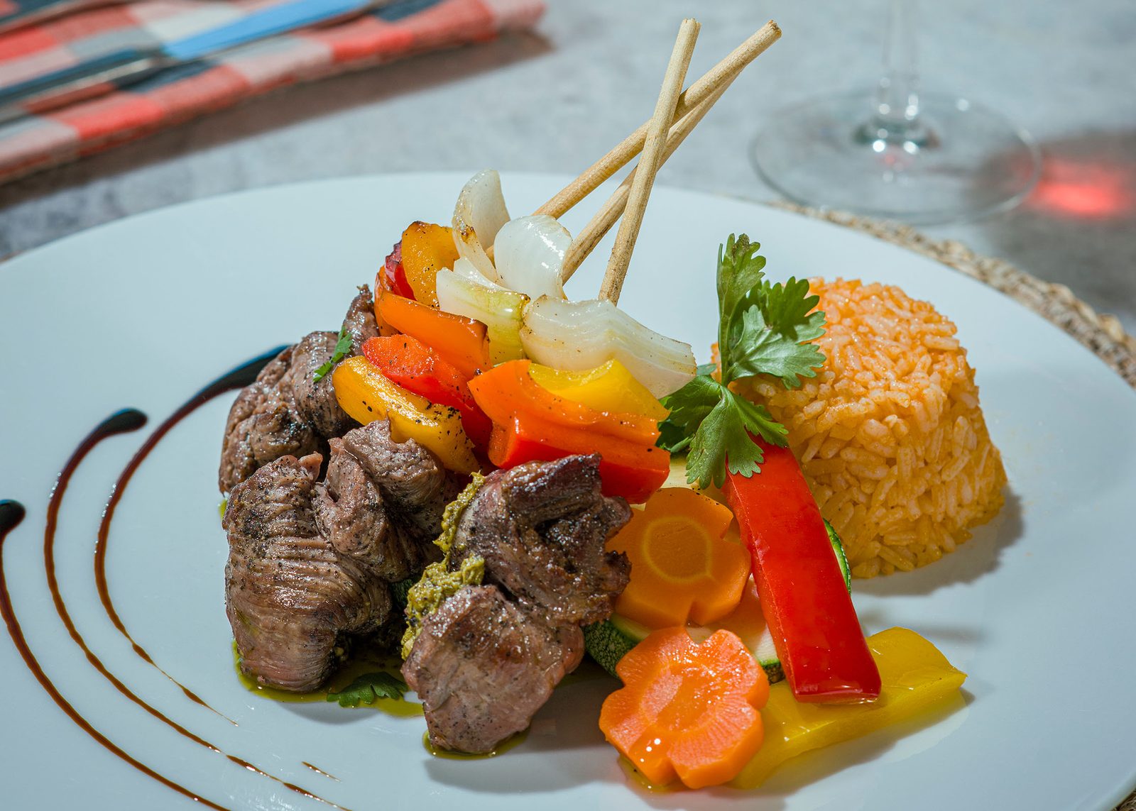 Grilled beef skewer with roasted peppers, onion and saffron rice