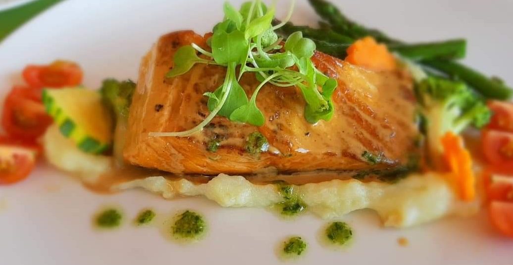 Pan-seared salmon over potato purée with asparagus and cherry tomatoes
